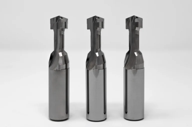 Drei präzisionsgefertigte Metallfräswerkzeuge auf weißem Hintergrund.