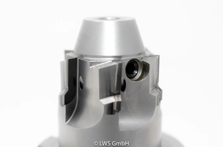 Nahaufnahme eines metallenen, zylindrischen Maschinenteils mit geriffelter Oberfläche und Schrauben.