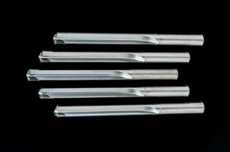 Sechs durchsichtige Glasröhren liegen nebeneinander auf schwarzem Hintergrund.
