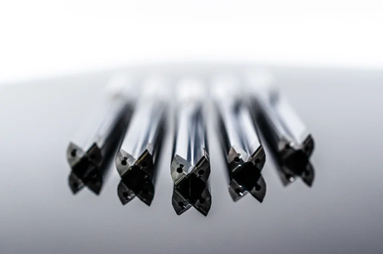 Nahaufnahme mehrerer schwarzer Kugelschreiberköpfe, die zu einem grauen Hintergrund zeigen.