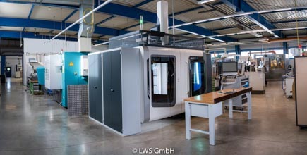 Moderne Produktionshalle mit mehreren industriellen Maschinen und hoher Decke.